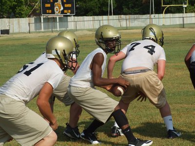 Image: Kyle Fortenberry(74) snaps the ball to Eric Carson as the JV Gladiators get in offensive reps.