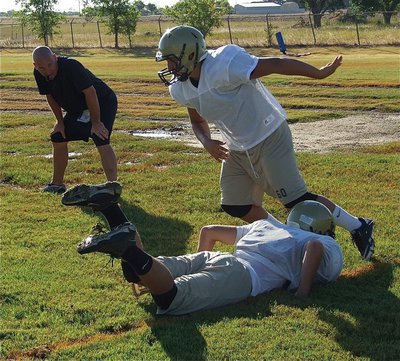 Image: Coach Jeff Richters watches his linebacker Kyle Jackson fight off a blocker.