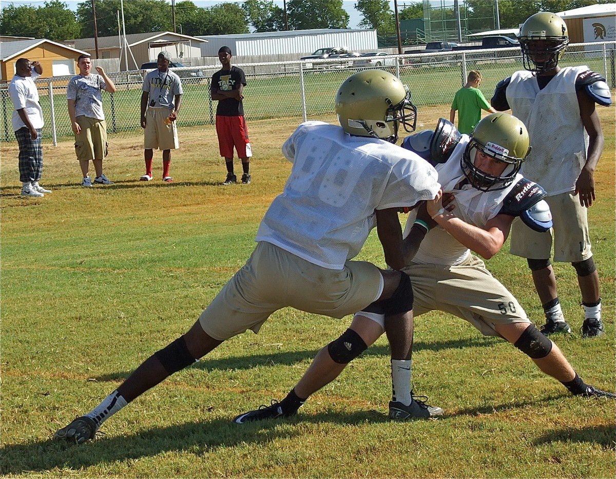 Image: Jase Holden attempts to fight off a block by Devonta Simmons, while former Gladiator players Bobby Wilson, Ross Enriquez, Jasenio Anderson and Aaron Thomas are on hand to show support.