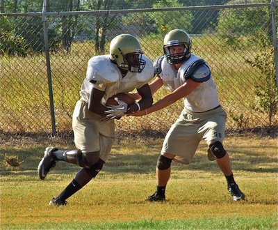 Image: Raheem Walker takes a handoff from quarterback Jase Holden.