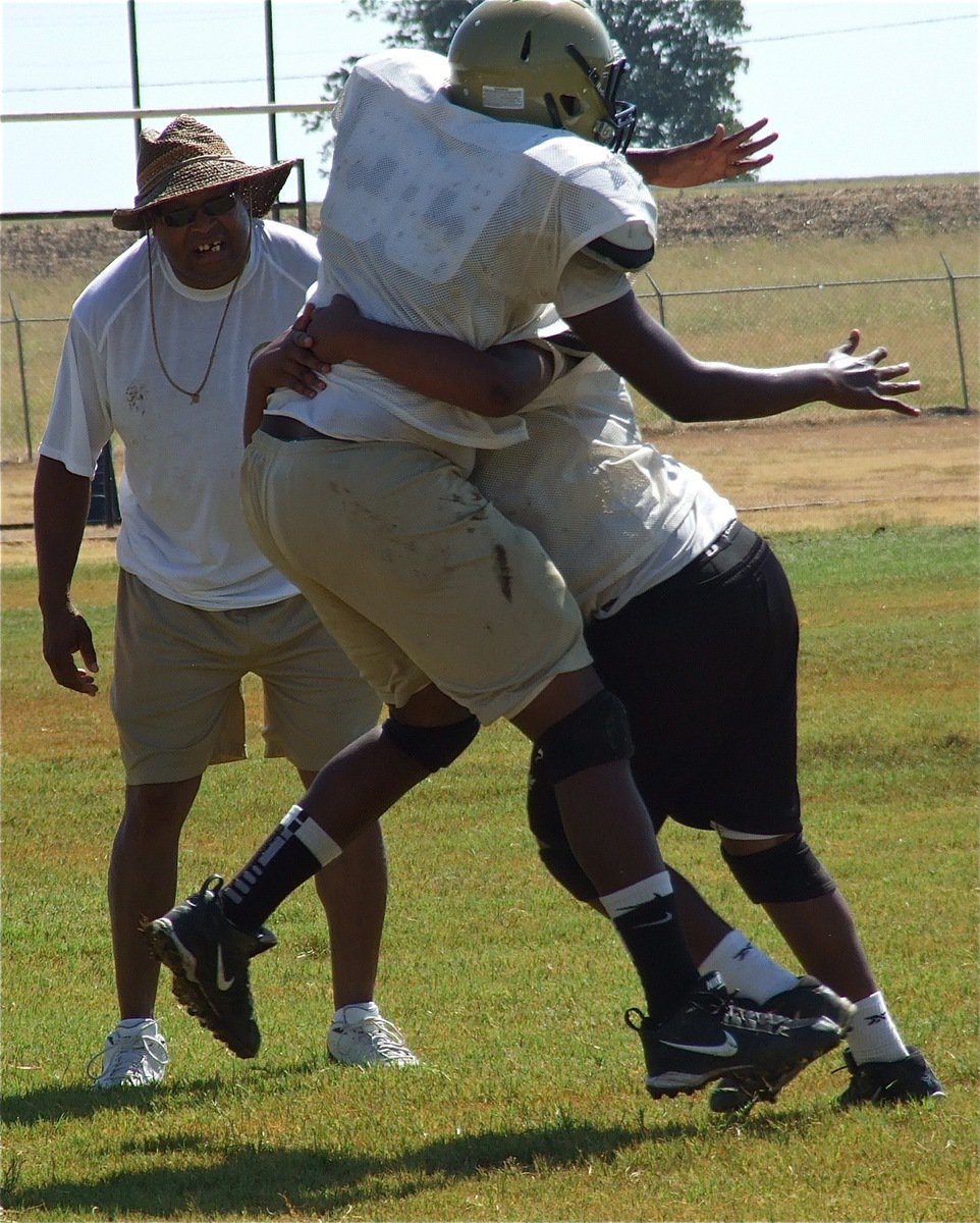 Image: Larry Mayberry, Sr. coaches, while youngest son Darol Mayberry, shows his might to older brother, Larry Mayberry, Jr. (Read that fast three times.)