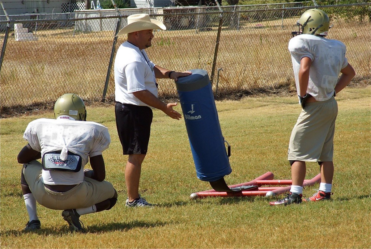 Image: Coach Bales talks blocking strategies with his backs.