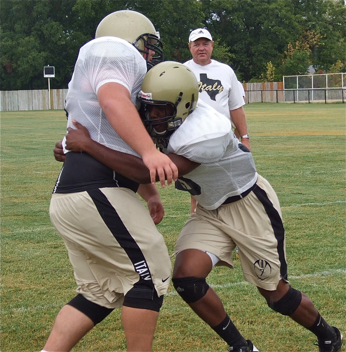 Image: Line coach Randy Parks looks on as Paul Harris form tackles teammate, Hank Seabolt.