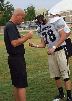 Image: Coach Jeff Richters bandages Brandon Souder after getting cut on his snapping hand.