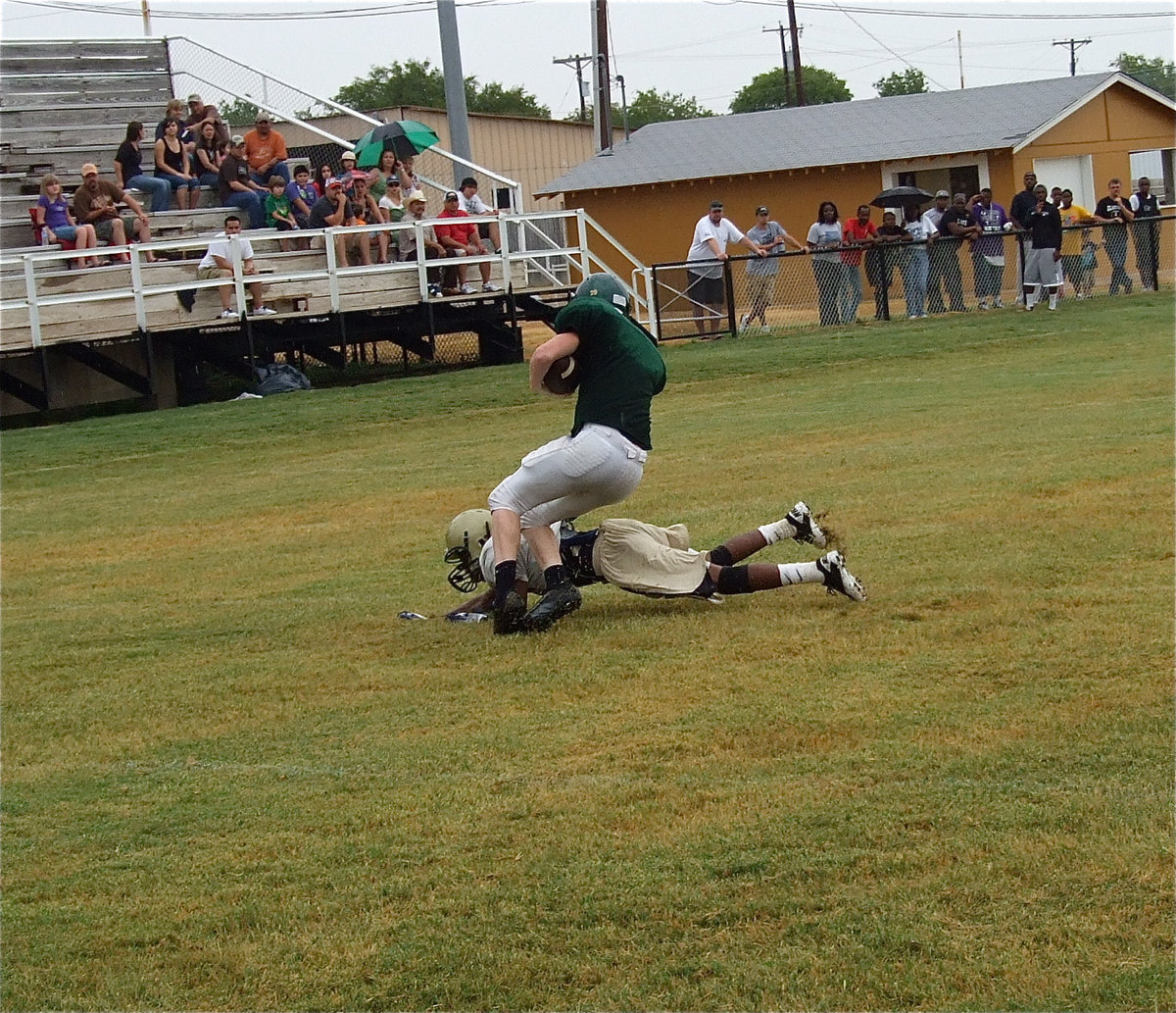 Image: Italy cornerback Eric Carson dives in for a leg tackle in the open field.