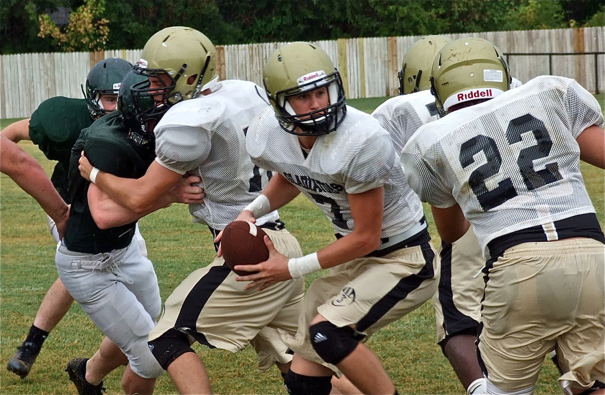 Image: Brandon Souder snaps to Jase Holden(7) as Kyle Jackson(22) leads thru the hole.