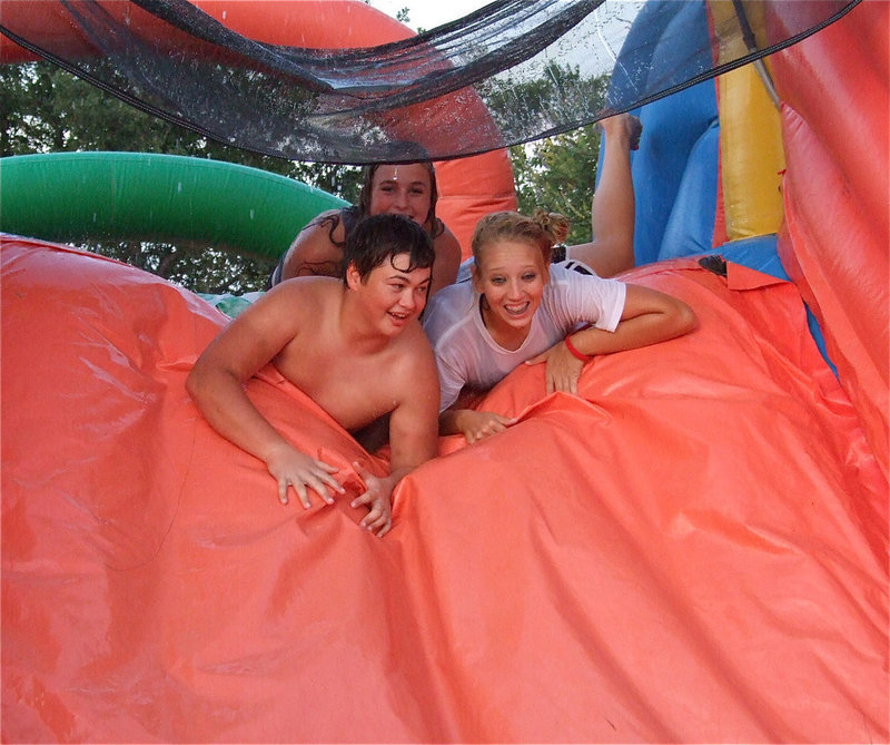 Image: Zain Byers, Madison Washington and Megan Richards prepare to slide into a pool of water.