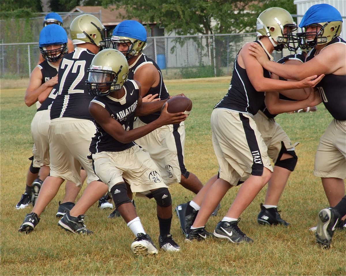 Image: Eric Carson takes the snap from center Bailey Walton and looks to hand it off.