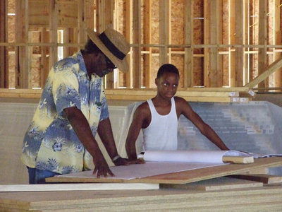 Image: Long time member, Christopher Speed, and newcomer, Darrell Swanson, look over the plans for the new church.