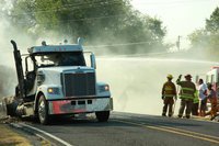 Image: Local fire departments begin to extinguish a burning 18 wheeler after it came to a stop just past David’s Supermarket on Highway 34 in Italy.