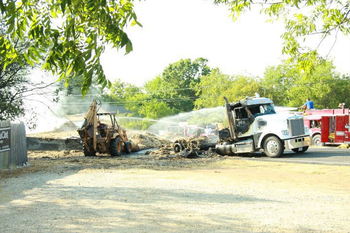 Image: Photographer, Jessica Clark, snaps shots of the fire scene after the burned 18 wheeler came to a rest in front of the McGrawClark Photography location. 