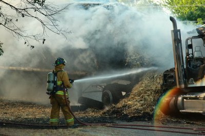 Image: Fire crews douse the smoldering hay and prevent further damage to the surrounding neighborhood.