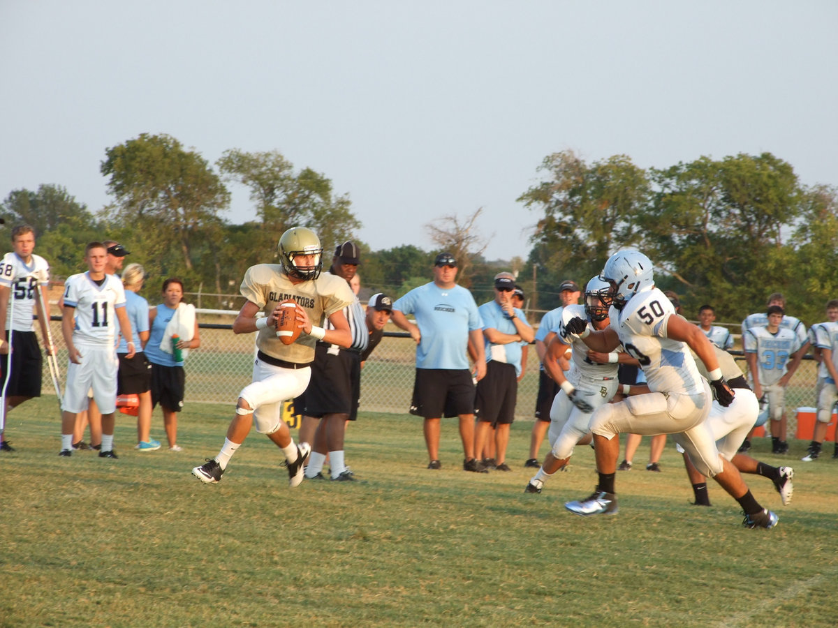 Image: Jase Holden rolls out and looks for a receiver wearing a gold jersey.