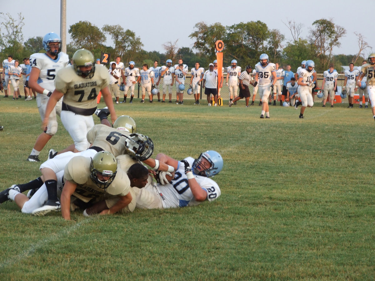 Image: Once again, Devonta Simmons gets involved in some hard hitting action and loses his helmet as teammates, Ethan Saxon(48), and, Tony Wooldridge(6), assist on the tackle. 