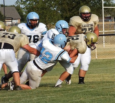 Image: Kelton Bales(73) and Hank Seabolt(77) try to help teammate, Shad Newman(32), fight for extra yards.
