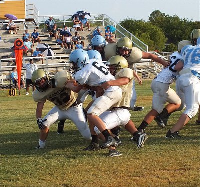 Image: Cody Medrano, Shad Newman(32) and Kelton Bales clamp down on a Cougar runner.