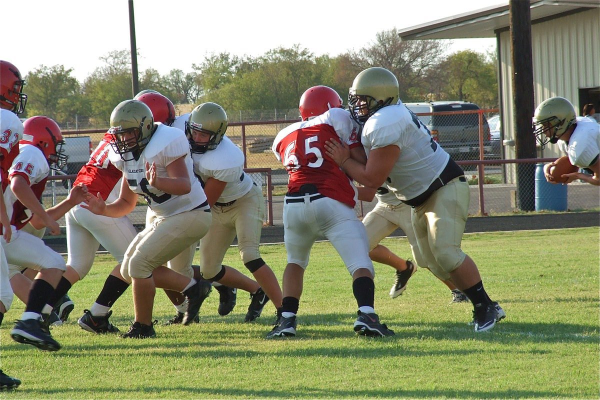 Image: Zain Byers(50), Bailey Walton(52) and Hank Seabolt(76) drive Maypearl’s defensive line backwards.