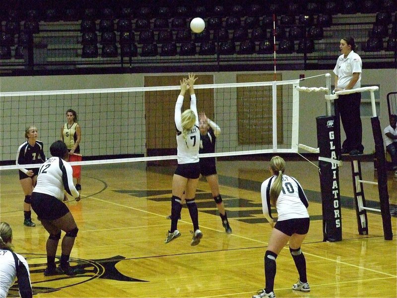 Image: Megan Richards(7) tries to execute a block at the net while Jimesha Reed(12) and Madison Washington(10) are ready to react.