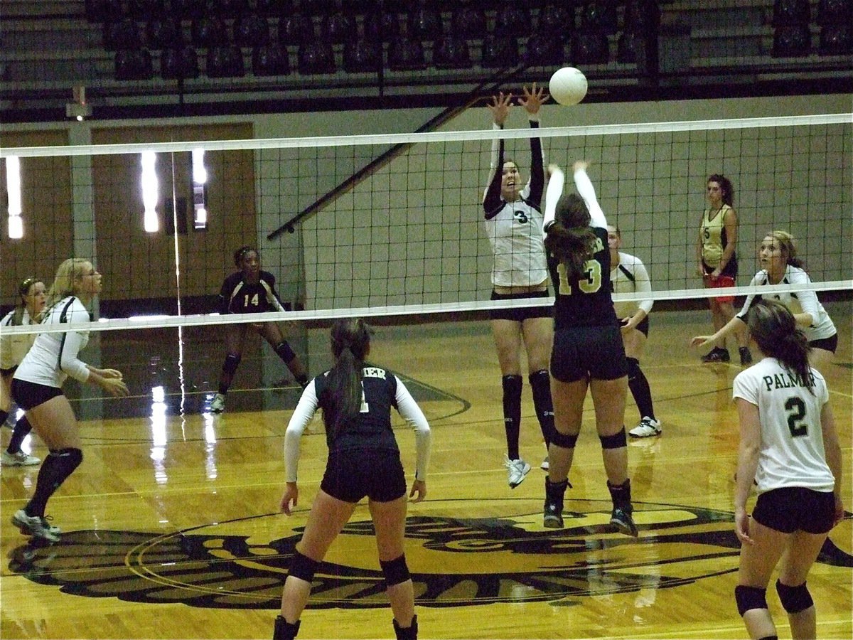 Image: Kaitlyn Rossa(3) tries to stuff the ball while Megan Richards(7) and Bailey Bumpus(8) get ready to respond.