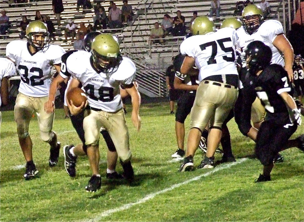 Image: Running every which way and loose, Justin Wood(48) dazzles fans with plenty of moves and a touchdown run after getting one last block from Kelton Bales(75).