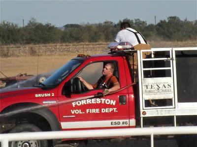 Image: Multitasking; a pair of Forreston firefighters do the work of three men. 