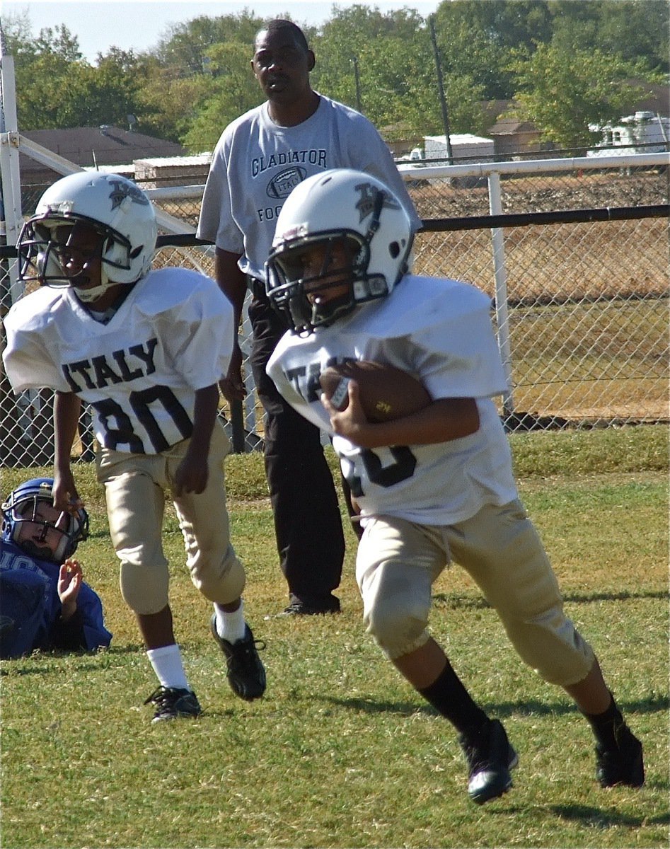 Image: C-Team assistant coach Michael Davis looks on as Darrin Jackson(80) lead blocks for quarterback Laveranues Green(10).