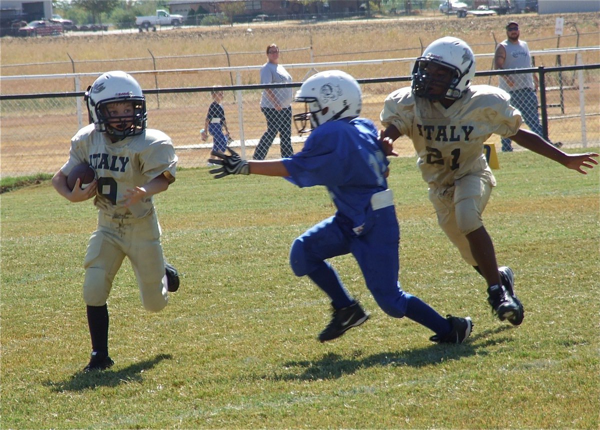 Image: Preston Rasco(9) returns the kickoff while teammate Ricky Pendleton(21) attempts to throw a block.