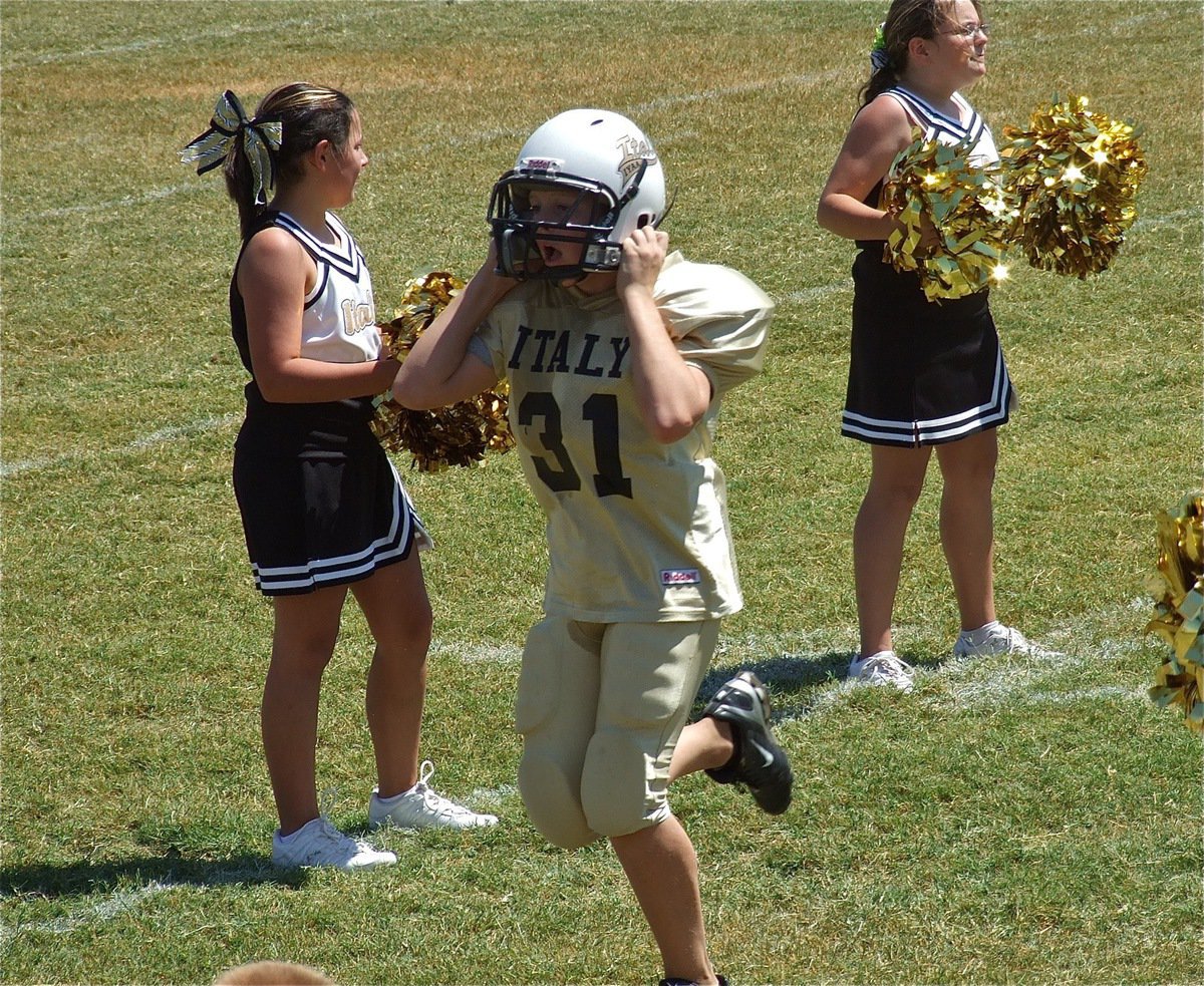 Image: Clay Riddle(31) gets cheered on by the IYAA A-Team Cheerleaders as he takes a victory trot thru spirit alley.