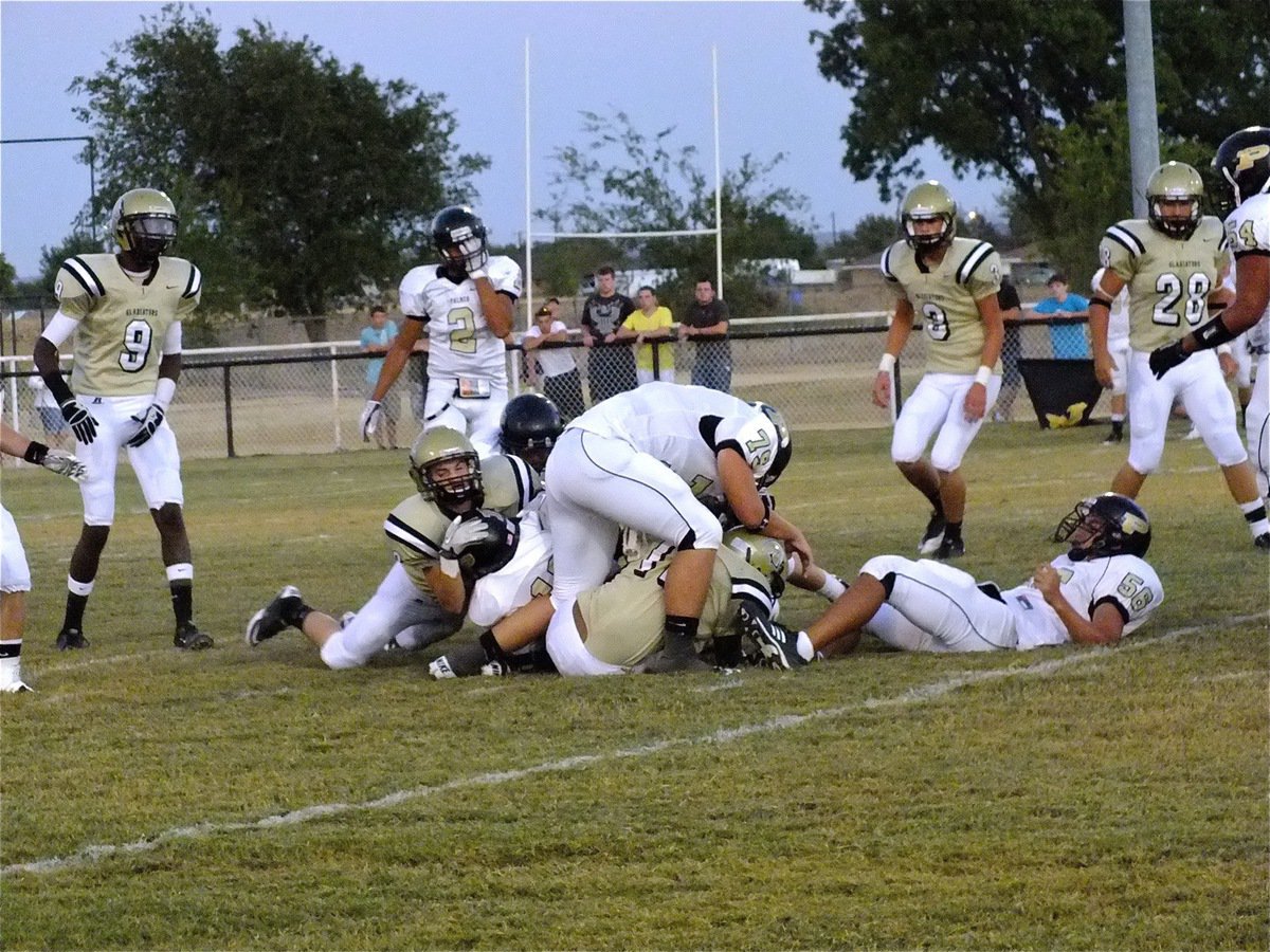 Image: Hayden Woods(8) and Ryheem Walker(10) get a hold on Palmer’s quarterback.