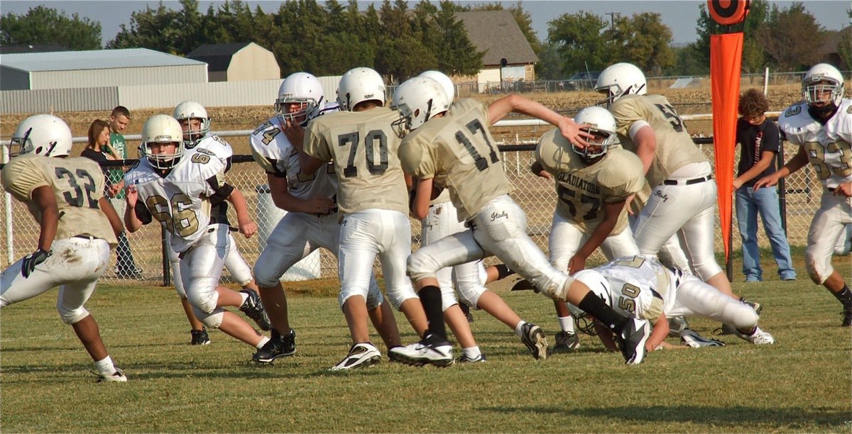 Image: Ryan Connor(17) hits full stride behind blockers Jaray Anderson(32), David De La Hoya(70), Kenneth Norwood, Jr.(57) and Aaron Pittmon(50).