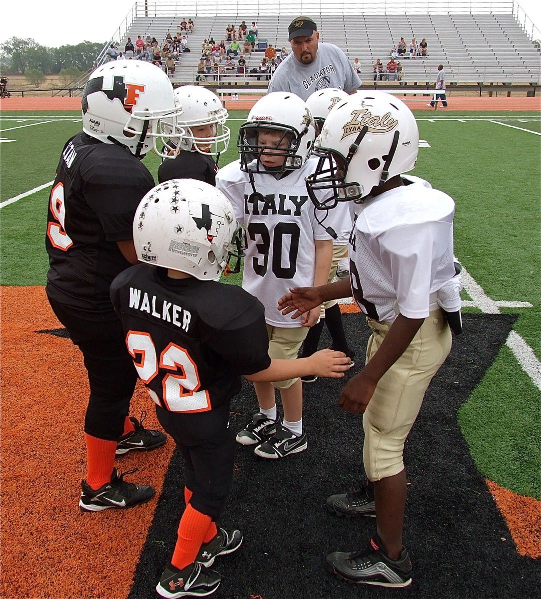 Image: IYAA C-Team (K-2nd) captains Isaac Todd(30) and Julius Williams(88) wish the Ferris Yellow Jacket captains good luck in an early season rematch from the 2010 NESA Bantam Division Superbowl.