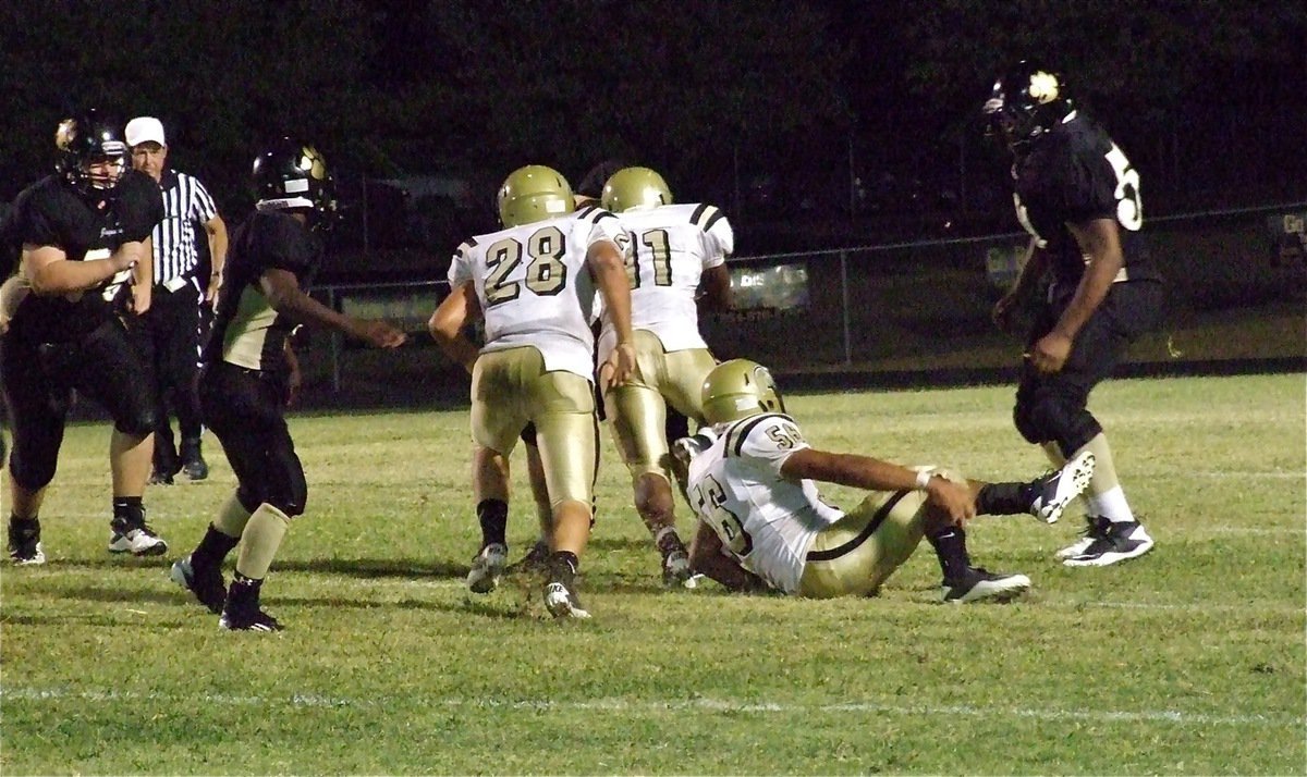 Image: Kyle Jackson(28) and Omar Estrada(56) help teammate Jalarnce Jamal Lewis(11) sack the Jaguar quarterback.