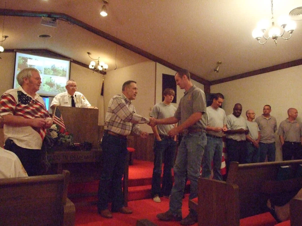 Image: Eric Bradley received a commemorative coin, a small token of thanks from Larry Norcross.