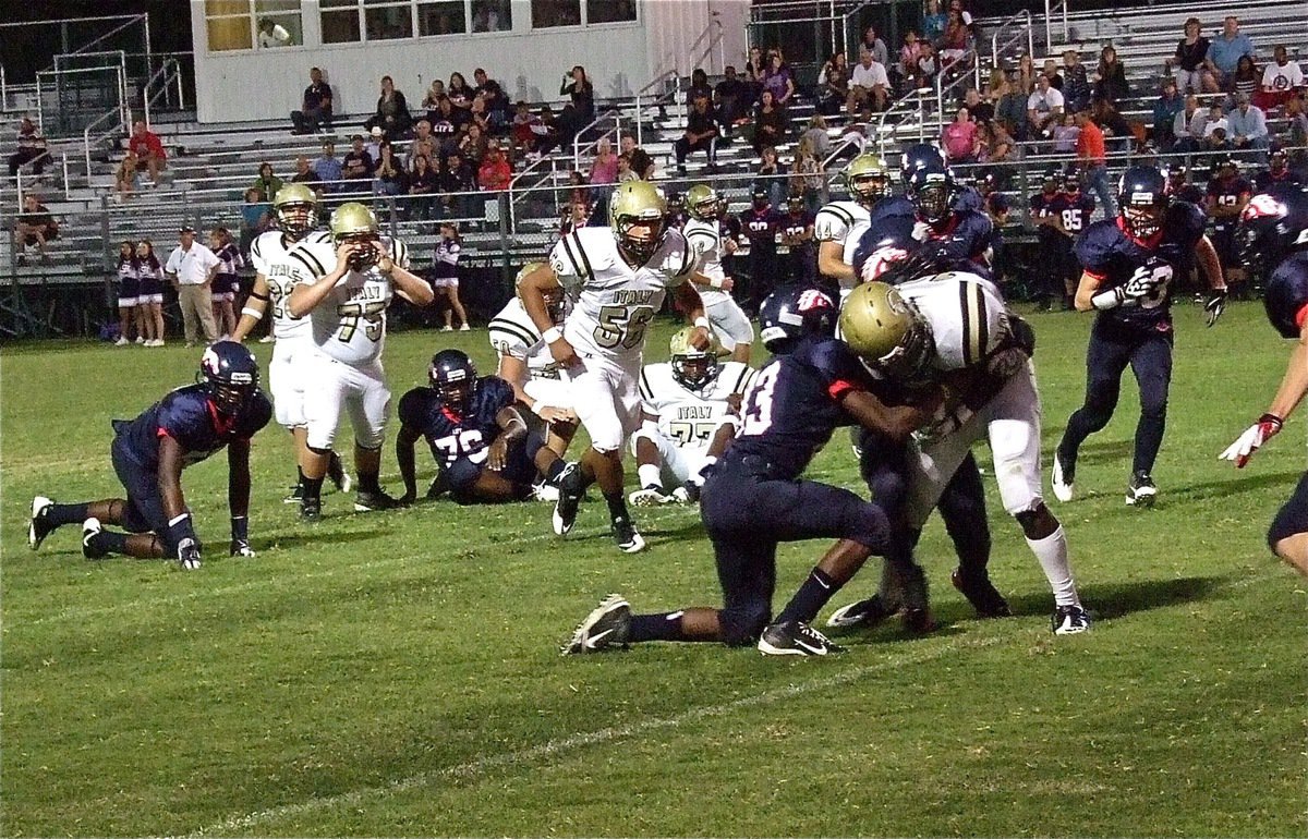 Image: The Mustangs attempt to keep Ryheem Walker(10) from reaching the goal line.