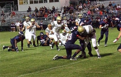Image: The Mustangs attempt to keep Ryheem Walker(10) from reaching the goal line.