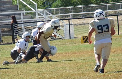 Image: IYAA A-team receiver Kendrick Norwood(10) tries to pull free from the Bulldogs that are nipping at his heels while teammate and center Austin Lowe(93) rushes over to help.