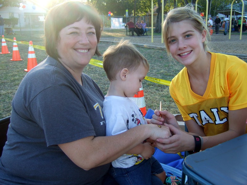 Image: Jenny Bales, Kix Bales and Haley Turner having fun as Haley paints a football on Jenny’s hand!