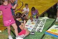 Image: IYAA Cheerleaders work on painting signs for the upcoming homecoming game during their private cheerleading camp hosted by the Italy High School cheerleaders.
