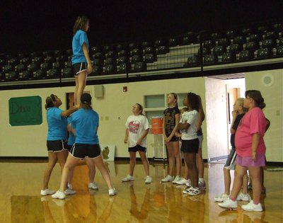 Image: The IHS varsity cheerleaders demonstrate a stunt for the young campers.