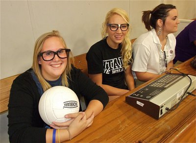 Image: Drenda Burk and Megan Richards keep the clock during the Student and Staff volleyball game. Kaytlyn Bales does her best not to be associated with these nerds but the nerd glasses give her away.