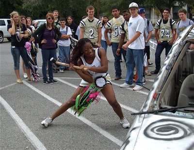 Image: IHS Cheerleader Jameka Copeland takes a swing during the sophomore sponsored Car Bash.