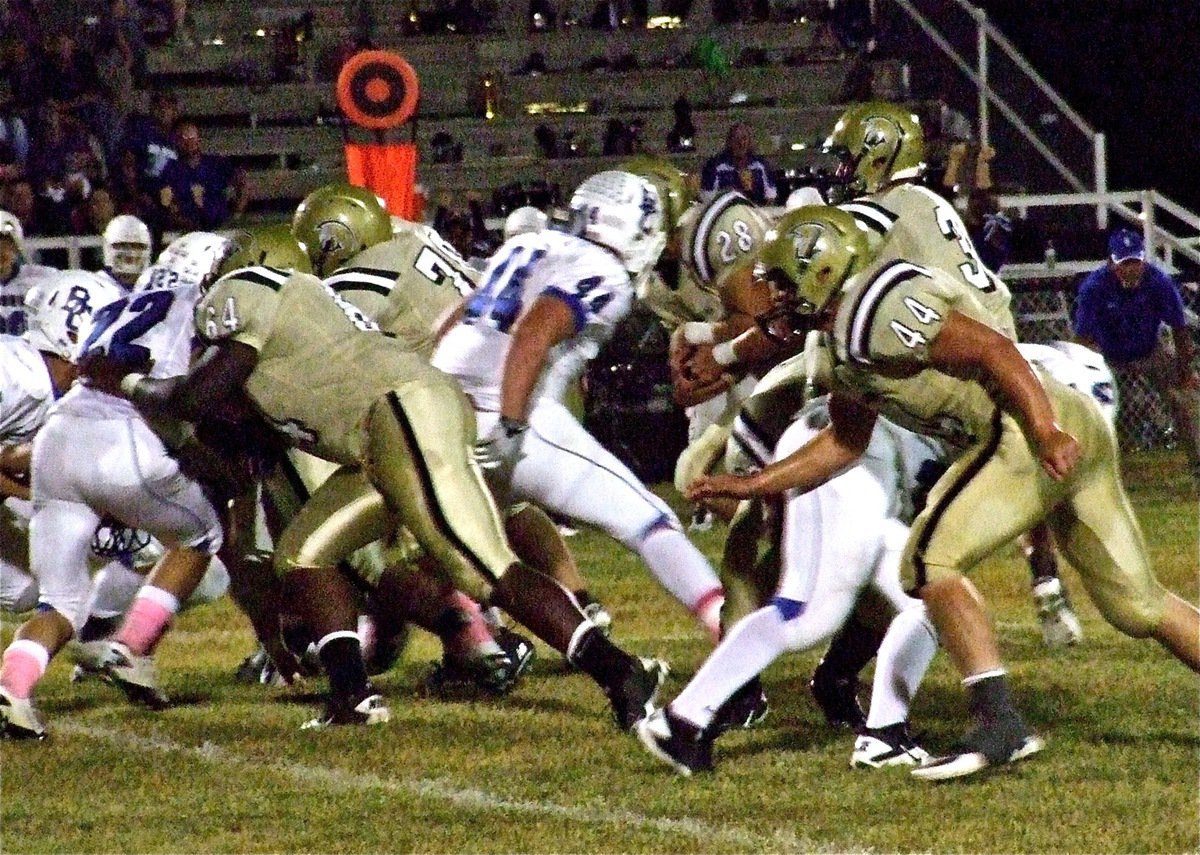 Image: Adrian Reed(64), Isaac Medrano(70) and Ethan Saxon(44) push their way thru the Lion defense as Jase Holden(3) handsoff to Kyle Jackson(28).