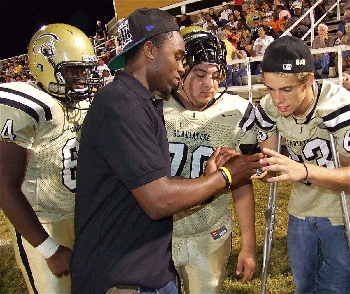 Image: Jasenio Anderson shows a text regarding Mayberry’s touchdown play to Brandon Souder(63), Isaac Medrano(70) and Adrian Reed(64).