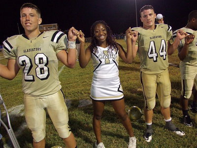 Image: Kyle Jackson(28), IHS Cheerleader Jameka Copeland and Ethan Saxon(44) are beaming with pride during the school song.