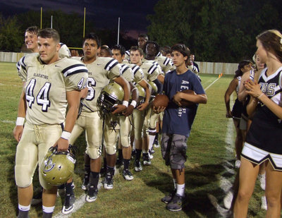 Image: Ethan Saxon(44) and his Gladiator teammates all stand at attention for the National Anthem.