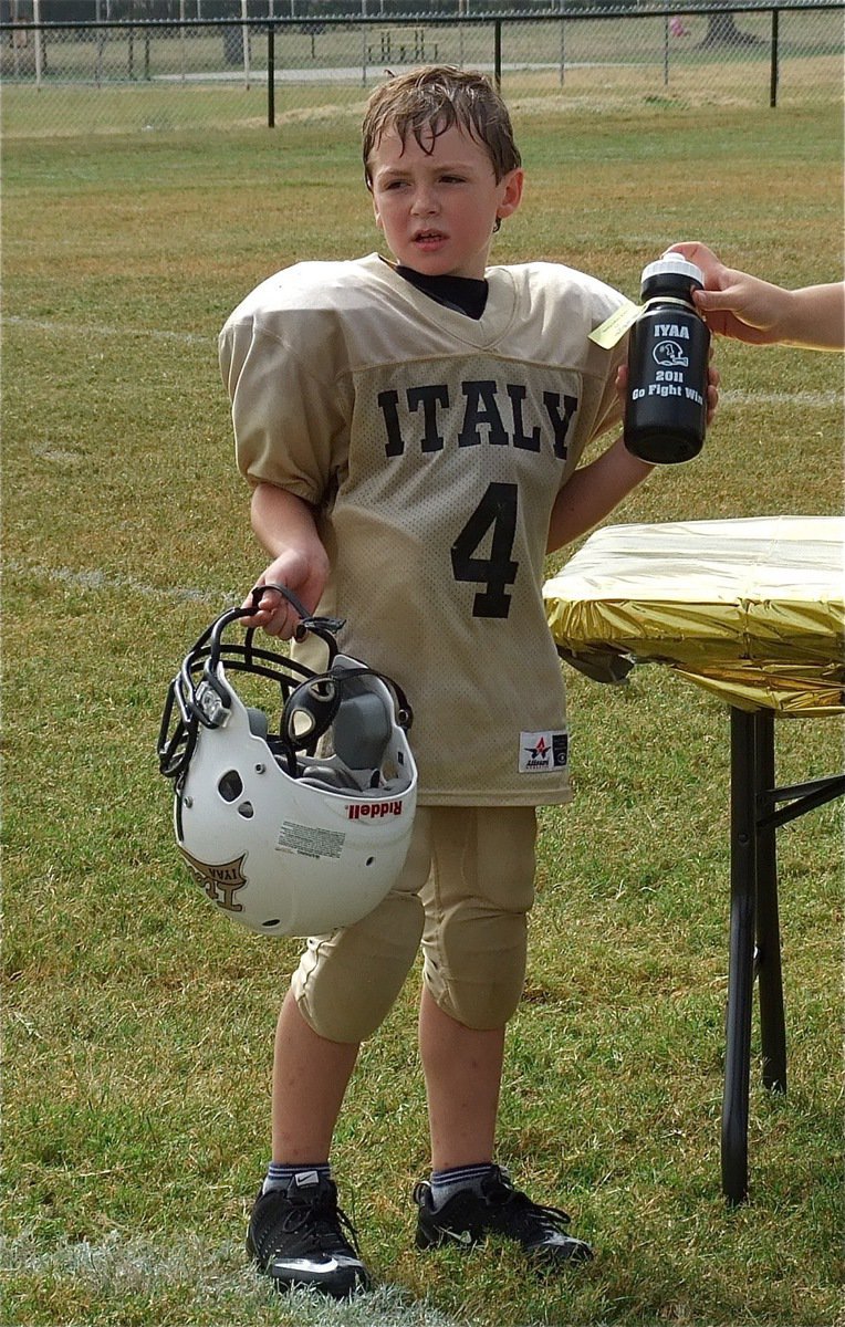 Image: Bryce DeBorde receives a squirt bottle and football after the IYAA B-Team’s homecoming win over the Hubbard Jaguars, 30-26.