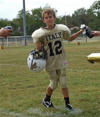 Image: IYAA B-Team linebacker/quarterback Parker Richters receives his squirt bottle and football after Italy’s 30-26 Homecoming win over Hubbard.
