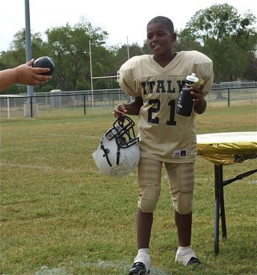 Image: IYAA B-Team’s Ricky Pendleton(21) is all smiles after getting the homecoming win over Hubbard and then receiving his squirt bottle and football.