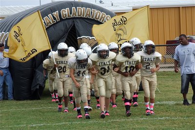 Image: Here come your IYAA A-Team Gladiators! Gary Escamilla(40), Clay Riddle(31), Kendrick Norwood(10) and Tylan Wallace(2) lead their team onto Willis Field to face the Hubbard Jaguars.