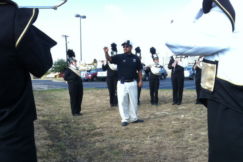Image: Band Director, Jesus Perez, conducts warm up drills before the competition